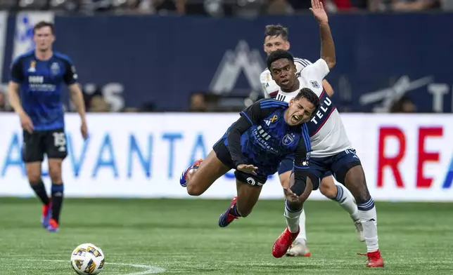 San Jose Earthquakes' Hernan, front left, and Vancouver Whitecaps' Ralph Priso, front right, collide as they vie for the ball during the first half of an MLS soccer match in Vancouver, British Columbia, Saturday, Sept. 14, 2024. (Ethan Cairns/The Canadian Press via AP)