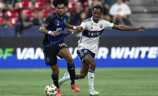 San Jose Earthquakes' Rodrigues, left, and Vancouver Whitecaps' Ali Ahmed, right, vie for the ball during the first half of an MLS soccer match in Vancouver, British Columbia, Saturday, Sept. 14, 2024. (Ethan Cairns/The Canadian Press via AP)