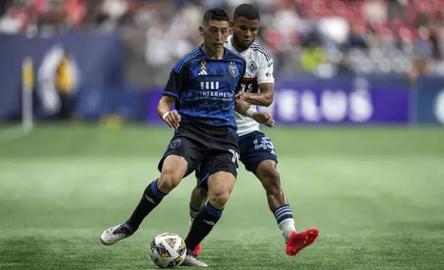 San Jose Earthquakes' Cristian Espinoza, left, and Vancouver Whitecaps' Pedro Vite, right, vie for the ball during the first half of an MLS soccer match in Vancouver, British Columbia, Saturday, Sept. 14, 2024. (Ethan Cairns/The Canadian Press via AP)