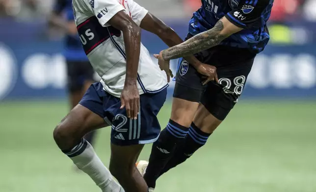 Vancouver Whitecaps' Ali Ahmed, left, and San Jose Earthquakes' Benji Kikanovic (28) vie for the ball during the first half of an MLS soccer match in Vancouver, British Columbia, Saturday, Sept. 14, 2024. (Ethan Cairns/The Canadian Press via AP)