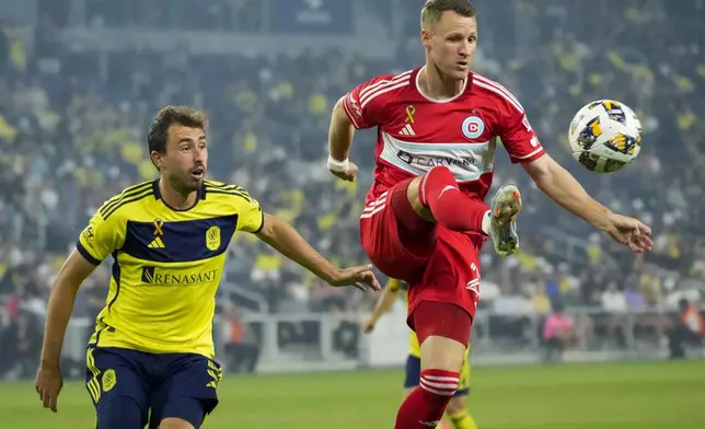 Chicago Fire midfielder Fabian Herbers, right, kicks the ball past Nashville SC defender Jack Maher, left, during the first half of an MLS soccer match Wednesday, Sept. 18, 2024, in Nashville, Tenn. (AP Photo/George Walker IV)