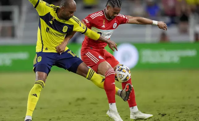 Nashville SC forward Teal Bunbury, left, and Chicago Fire defender Ariel Lassiter, right, battle for the ball during the first half of an MLS soccer match Wednesday, Sept. 18, 2024, in Nashville, Tenn. (AP Photo/George Walker IV)