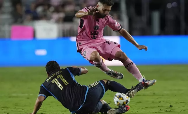 Inter Miami defender Jordi Alba (18) jumps over Philadelphia Union midfielder Alejandro Bedoya (11) during the second half of an MLS soccer match, Saturday, Sept. 14, 2024, in Fort Lauderdale, Fla. (AP Photo/Marta Lavandier)