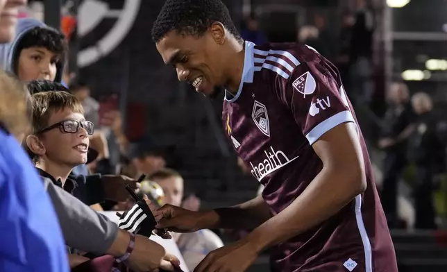 Colorado Rapids defender Reggie Cannon, right, smiles while giving autographs after an MLS soccer match against Toronto FC Saturday, Sept. 21, 2024, in Commerce City, Colo. (AP Photo/Jack Dempsey)