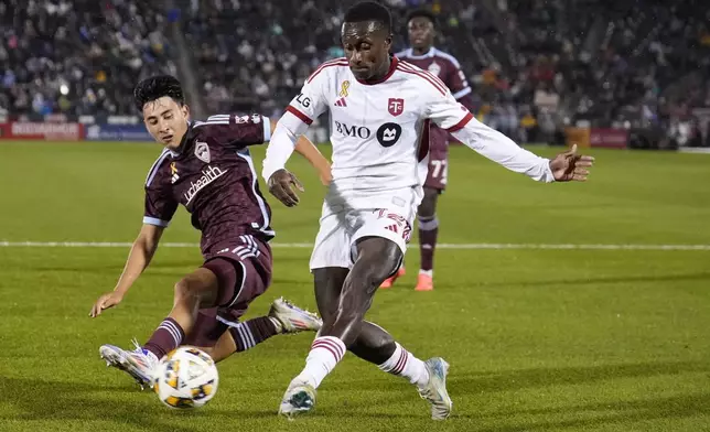 Toronto FC midfielder Richie Laryea, front right, shoots on goal against Colorado Rapids defender Sebastian Anderson, left, during the second half of an MLS soccer match Saturday, Sept. 21, 2024, in Commerce City, Colo. (AP Photo/Jack Dempsey)