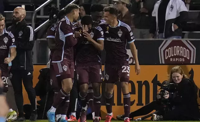 Colorado Rapids defender Reggie Cannon (4) is congratulated by teammates Rafael Navarro, center left, and Cole Bassett (23) after scoring a goal against Toronto FC during the second half of an MLS soccer match Saturday, Sept. 21, 2024, in Commerce City, Colo. (AP Photo/Jack Dempsey)