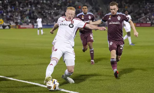 Toronto FC midfielder Matty Longstaff (8) tries to keep the ball in bounds against Colorado Rapids midfielder Connor Ronan (20) during the second half of an MLS soccer match Saturday, Sept. 21, 2024, in Commerce City, Colo. (AP Photo/Jack Dempsey)