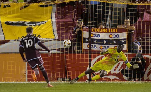 Colorado Rapids midfielder Djordje Mihailović (10) scores against Toronto FC goalkeeper Sean Johnson, right, during the second half of an MLS soccer match Saturday, Sept. 21, 2024, in Commerce City, Colo. (AP Photo/Jack Dempsey)