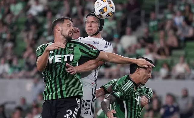 Austin FC defender Matt Hedges (2) and Vancouver Whitecaps defender Bjørn Inge Utvik (15) jump for a pass during the second half of an MLS soccer match in Austin, Texas, Saturday, Aug. 31, 2024. (AP Photo/Eric Gay)