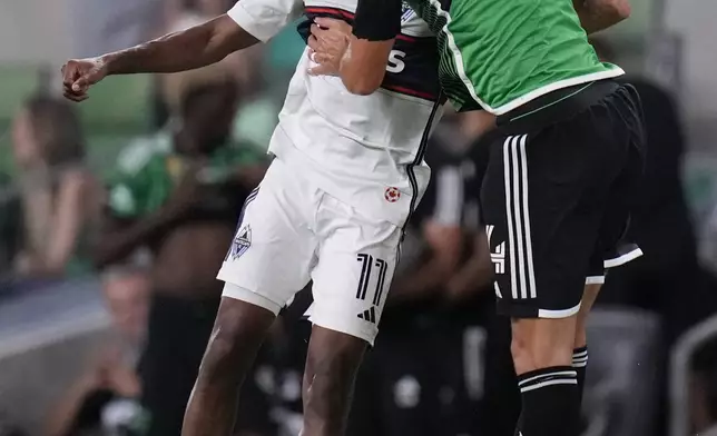 Vancouver Whitecaps midfielder Fafa Picault (11) and Austin FC defender Brendan Hines-Ike (4) leap to head the ball during the second half of an MLS soccer match in Austin, Texas, Saturday, Aug. 31, 2024. (AP Photo/Eric Gay)