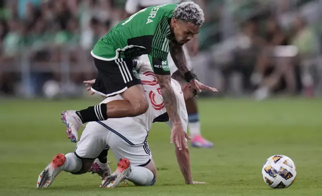 Austin FC midfielder Daniel Pereira, top, trips over Vancouver Whitecaps midfielder Ryan Gauld (25) during the second half of an MLS soccer match in Austin, Texas, Saturday, Aug. 31, 2024. (AP Photo/Eric Gay)