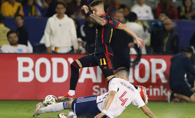 Vancouver Whitecaps’ Ranko Veselinovic (4) tackles Los Angeles Galaxy’s Gabriel Pec (11) during the second half of an MLS soccer match Saturday, Sept. 21, 2024, in Carson, Calif. (AP Photo/Etienne Laurent)