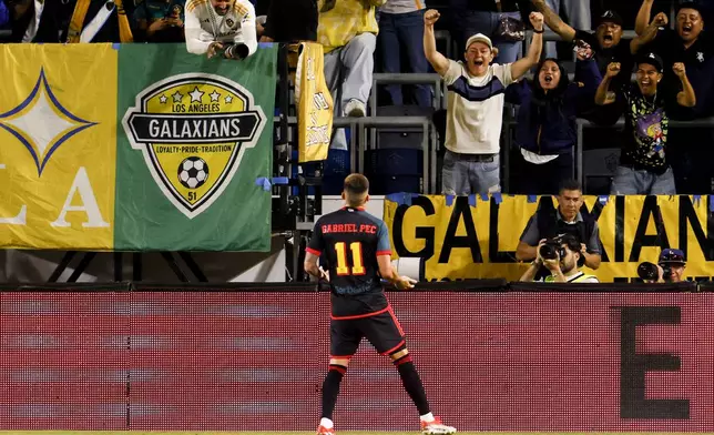 Los Angeles Galaxy supporters cheer as Los Angeles Galaxy's Gabriel Pec (11) celebrates his goal against the Vancouver Whitecaps during the first half of an MLS soccer match Saturday, Sept. 21, 2024, in Carson, Calif. (AP Photo/Etienne Laurent)