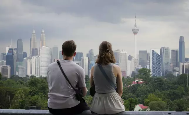 A couple enjoy the view of Kuala Lumpur city skyline at a popular viewing area in Kuala Lumpur, Malaysia, Wednesday, Sept. 18, 2024. (AP Photo/Vincent Thian)