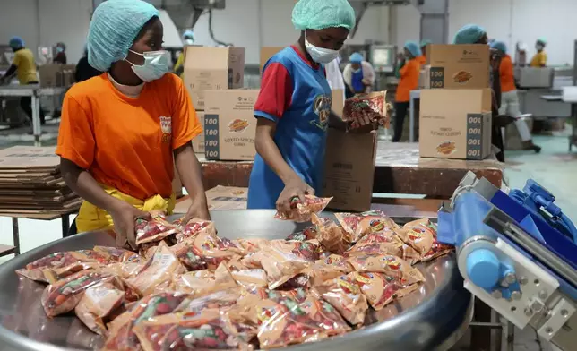 Workers collect bouillon cubes packages at the Sweet Nutrition factory in Otta, Nigeria, Thursday, Sept. 12, 2024. (AP Photo/Sunday Alamba)