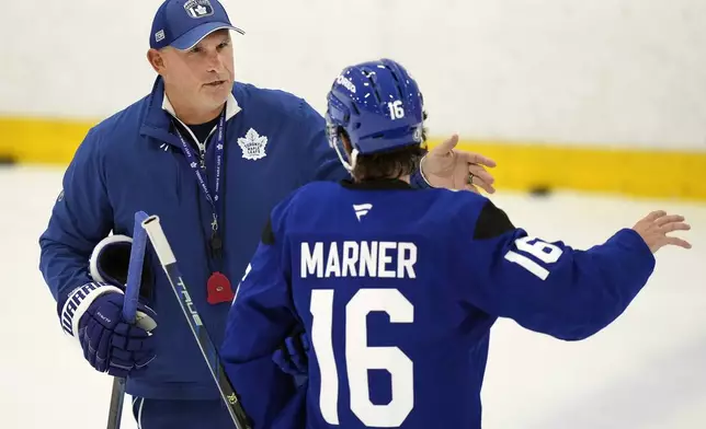 Toronto Maple Leafs new head coach Craig Berube, left, talks with forward Mitch Marner during NHL training camp in Toronto, Thursday, Sept. 19, 2024. (Nathan Denette/The Canadian Press via AP)