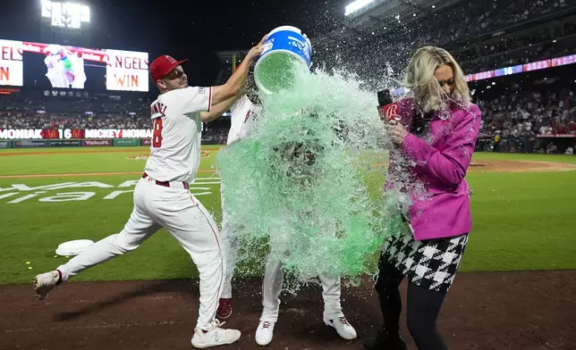 Los Angeles Angels' Mickey Moniak, center, is doused after hitting a walk-off home run during the ninth inning of a baseball game against the Seattle Mariners in Anaheim, Calif., Saturday, Aug. 31, 2024. The Angels won 5-4. (AP Photo/Ashley Landis)