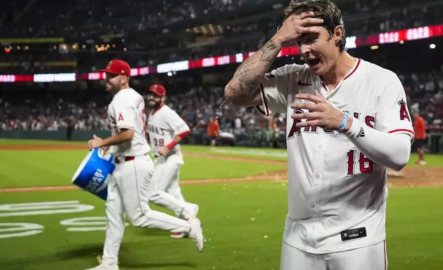 Los Angeles Angels' Mickey Moniak (16) reacts after being doused by teammates after hitting a walk-off home run during the ninth inning of a baseball game against the Seattle Mariners in Anaheim, Calif., Saturday, Aug. 31, 2024. The Angels won 5-4. (AP Photo/Ashley Landis)