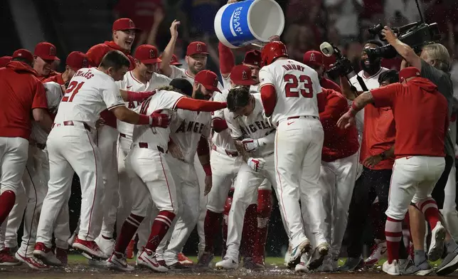 Los Angeles Angels' Mickey Moniak (16) celebrates with teammates after hitting a walk-off home run during the ninth inning of a baseball game against the Seattle Mariners in Anaheim, Calif., Saturday, Aug. 31, 2024. The Angels won 5-4. (AP Photo/Ashley Landis)