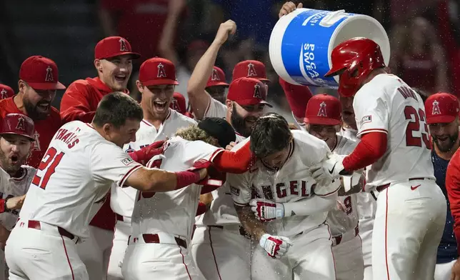 Los Angeles Angels' Mickey Moniak (16) celebrates with teammates after hitting a walk-off home run during the ninth inning of a baseball game against the Seattle Mariners in Anaheim, Calif., Saturday, Aug. 31, 2024. The Angels won 5-4. (AP Photo/Ashley Landis)