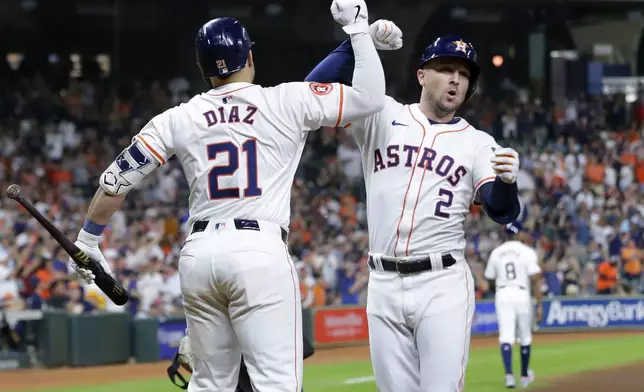 Houston Astros' Yainer Diaz (21) and Alex Bregman (2) celebrate a solo home run by Bregman during the first inning of a baseball game against the Seattle Mariners, Tuesday, Sept. 24, 2024, in Houston. (AP Photo/Michael Wyke)