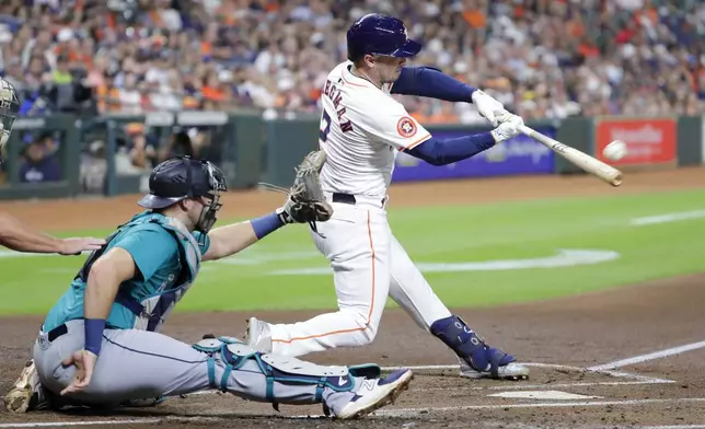 Houston Astros' Alex Bregman (2) connects for a home run in front of Seattle Mariners catcher Cal Raleigh, left, during the first inning of a baseball game Tuesday, Sept. 24, 2024, in Houston. (AP Photo/Michael Wyke)