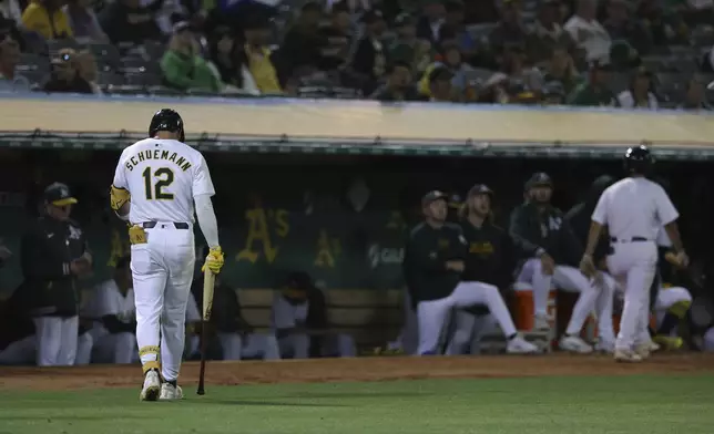 Oakland Athletics' Max Schuemann (12) walks back to the dugout after striking out during the fifth inning of a baseball game against the Seattle Mariners in Oakland, Calif., Wednesday, Sept. 4, 2024. (AP Photo/Jed Jacobsohn)