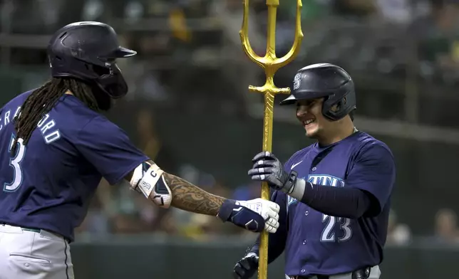 Seattle Mariners' Luis Urías (23) celebrates with J.P. Crawford (3) after hitting a home run against the Oakland Athletics during the seventh inning of a baseball game in Oakland, Calif., Wednesday, Sept. 4, 2024. (AP Photo/Jed Jacobsohn)