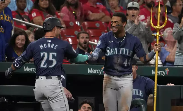 Seattle Mariners' Dylan Moore (25) is congratulated by teammate Julio Rodriguez (44) after hitting a two-run home run during the sixth inning of a baseball game against the St. Louis Cardinals Friday, Sept. 6, 2024, in St. Louis. (AP Photo/Jeff Roberson)