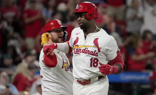 St. Louis Cardinals' Jordan Walker (18) is congratulated by teammate Pedro Pages after hitting a solo home run during the seventh inning of a baseball game against the Seattle Mariners Friday, Sept. 6, 2024, in St. Louis. (AP Photo/Jeff Roberson)