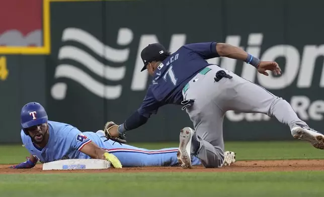 Texas Rangers' Leody Taveras, left, steals second base against Seattle Mariners second baseman Jorge Polanco (7) during the ninth inning of a baseball game Sunday, Sept. 22, 2024, in Arlington, Texas. (AP Photo/LM Otero)