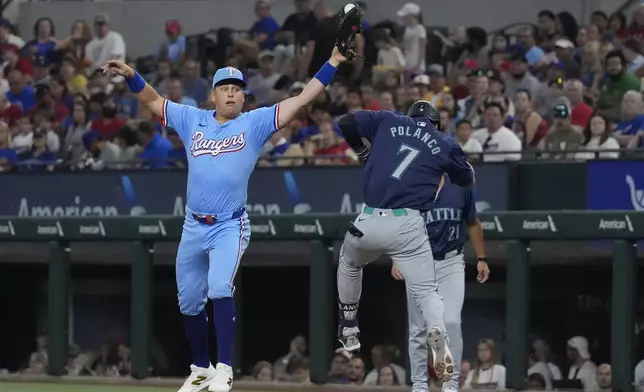 Texas Rangers first baseman Nathaniel Lowe, left, reaches for a throw from teammate Ezequiel Duran against Seattle Mariners' Jorge Polanco (7) for a groundout at first base during the second inning of a baseball game Sunday, Sept. 22, 2024, in Arlington, Texas. (AP Photo/LM Otero)