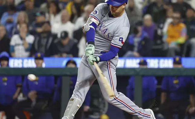 Texas Rangers' Nathaniel Lowe hits an RBI single in the first inning of a baseball game against the Seattle Mariners, Friday, Sept. 13, 2024, in Seattle. (Dean Rutz/The Seattle Times via AP)