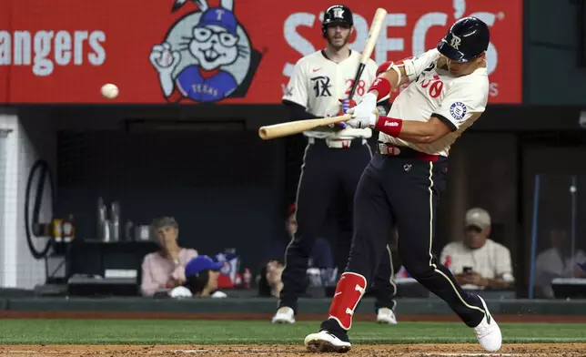 Texas Rangers' Nathaniel Lowe (30) hits a two-run single in the fourth inning of a baseball game against the Seattle Mariners, Friday, Sept. 20, 2024, in Arlington, Texas. (AP Photo/Richard W. Rodriguez)