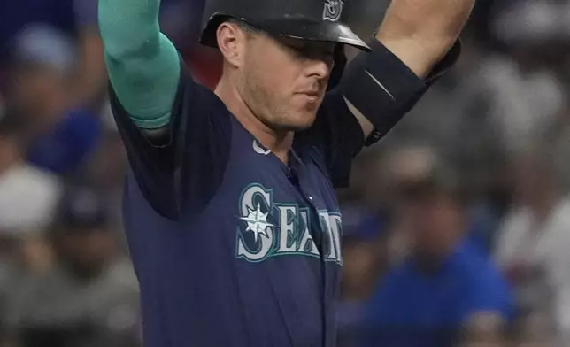 Seattle Mariners' Dylan Moore celebrates after his single that scored teammate Justin Turner during the second inning of a baseball game against the Texas Rangers, Sunday, Sept. 22, 2024, in Arlington, Texas. (AP Photo/LM Otero)