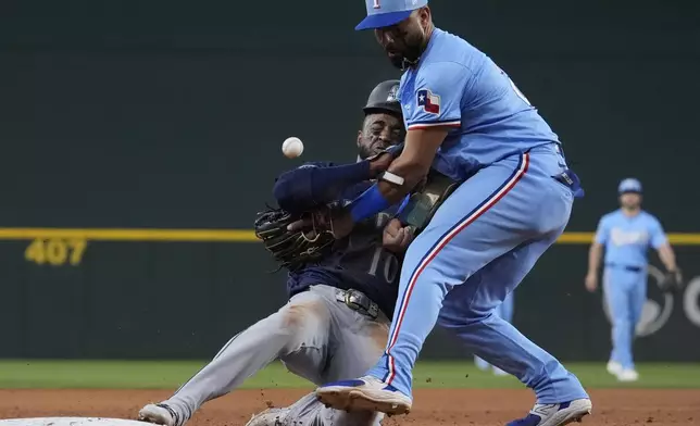 Seattle Mariners' Victor Robles (10) bumps into Texas Rangers third baseman Ezequiel Duran, front right, as a fielding error throw by Texas second baseman Marcus Semien misses the mark on a pickoff-attempt to third during the sixth inning of a baseball game Sunday, Sept. 22, 2024, in Arlington, Texas. (AP Photo/LM Otero)