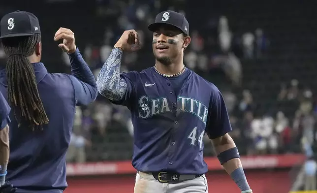 Seattle Mariners outfielder Julio Rodríguez (44) celebrates with teammates after a baseball game against the Texas Rangers, Saturday, Sept. 21, 2024, in Arlington, Texas. (AP Photo/LM Otero)