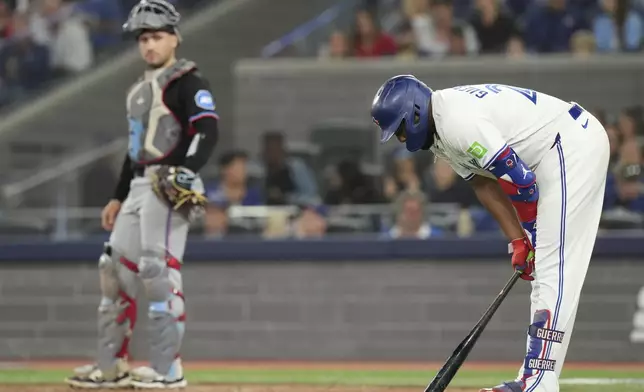 Toronto Blue Jays' Vladimir Guerrero Jr., right, reacts after being struck by a foul ball as Miami Marlins catcher Nick Fortes, left, looks on during fifth-inning baseball game action in Toronto, Friday, Sept. 27, 2024. (Chris Young/The Canadian Press via AP)