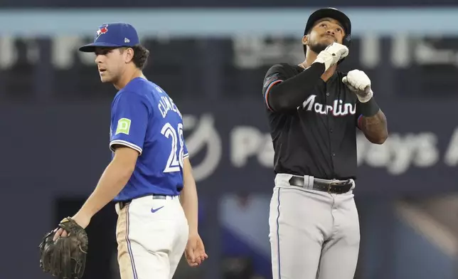 Miami Marlins' Dane Myers, right, celebrates next to Toronto Blue Jays shortstop Ernie Clement after hitting a two-run RBI double during the sixth inning of a baseball game in Toronto, Saturday, Sept. 28, 2024. (Chris Young/The Canadian Press via AP)