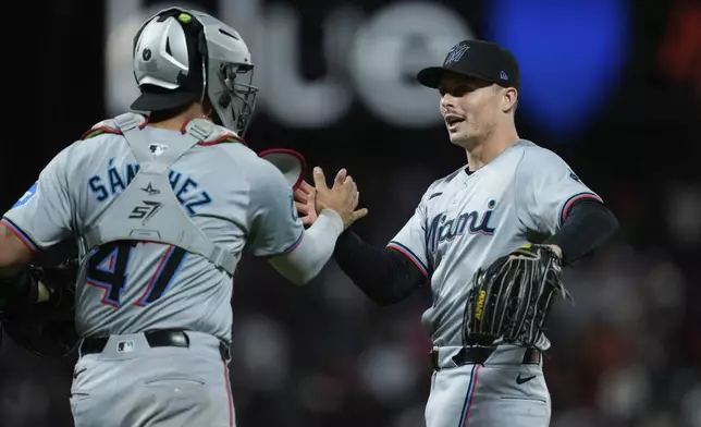 Miami Marlins pitcher Calvin Faucher, right, and catcher Ali Sánchez celebrate the team's victory over the San Francisco Giants in a baseball game Saturday, Aug. 31, 2024, in San Francisco. (AP Photo/Godofredo A. Vásquez)