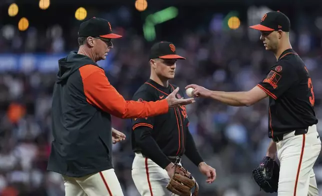 San Francisco Giants pitcher Taylor Rogers, right, hands the ball over to manager Bob Melvin, left, as he exits during the sixth inning of a baseball game against the Miami Marlins, Saturday, Aug. 31, 2024, in San Francisco. (AP Photo/Godofredo A. Vásquez)