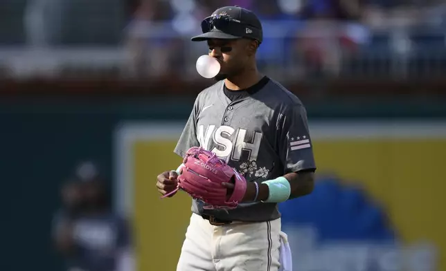 Washington Nationals shortstop Nasim Nunez blows a bubble as he stands on the field during the fourth inning of a baseball game against the Miami Marlins, Saturday, Sept. 14, 2024, in Washington. (AP Photo/Nick Wass)