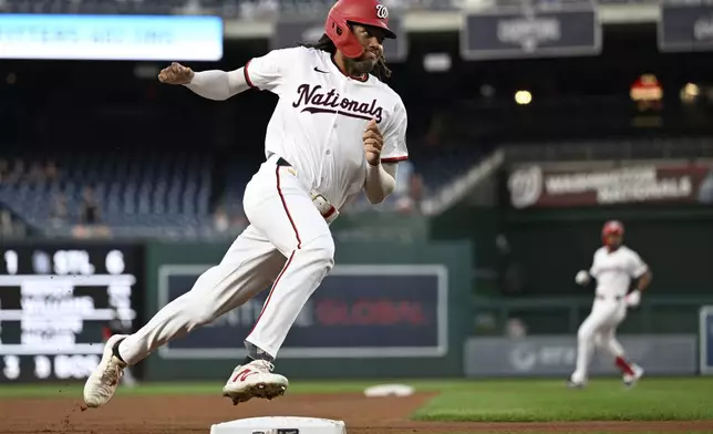 Washington Nationals' James Wood, foreground, rounds third base to score on a double by teammate Jose Tena during the first inning of a baseball game against the Miami Marlins, Thursday, Sept. 12, 2024, in Washington. (AP Photo/John McDonnell)