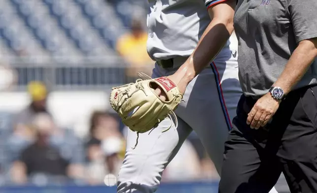 Miami Marlins relief pitcher John McMillon, left, leaves the field after an injury during the third inning of a baseball game against the Pittsburgh Pirates Wednesday, Sept. 11, 2024, in Pittsburgh. (AP Photo/Matt Freed)