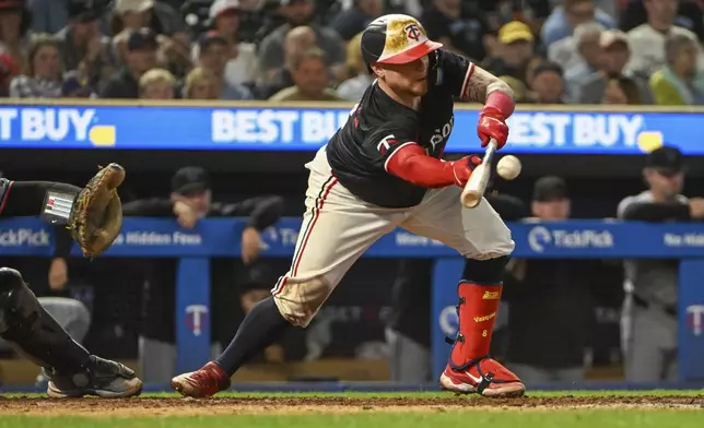 Minnesota Twins' Christian Vazquez (8) bunts allowing Manuel Margot to score against the Miami Marlins during the seventh inning of a baseball game, Wednesday, Sept. 25, 2024, in Minneapolis. The Twins won 8-3. (AP Photo/Craig Lassig)