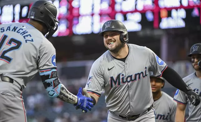 Miami Marlins' Jake Burger, right, celebrates with Jesus Sanchez after hitting a three-run home run against Minnesota Twins starting pitcher Simeon Woods Richardson during the first inning of a baseball game, Wednesday, Sept. 25, 2024, in Minneapolis. Connor Norby and Xavier Edwards also scored. (AP Photo/Craig Lassig)