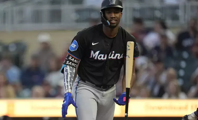 Miami Marlins' Jesús Sánchez flips his bat as he walks back to the dugout after striking out in the first inning of a baseball game against the Minnesota Twins, Thursday, Sept. 26, 2024, in Minneapolis. (AP Photo/Abbie Parr)