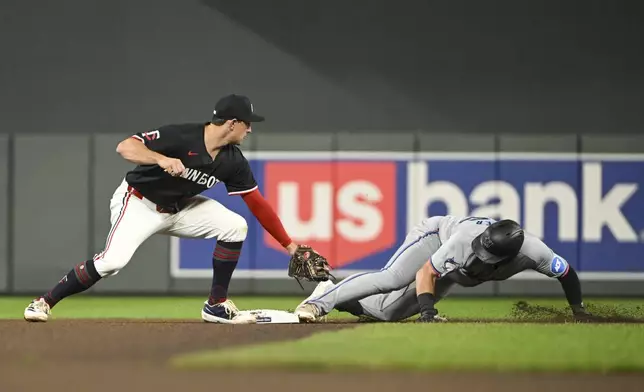 Miami Marlins' Jake Burger, right, is safe at second on a double as Minnesota Twins second baseman Brooks Lee misses the tag during the seventh inning of a baseball game, Wednesday, Sept. 25, 2024, in Minneapolis. The Twins won 8-3. (AP Photo/Craig Lassig)