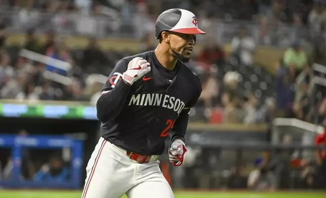 Minnesota Twins' Byron Buxton celebrates as he rounds the bases after hitting a home run against Miami Marlins starting pitcher Edward Cabrera during the fourth inning of a baseball game, Wednesday, Sept. 25, 2024, in Minneapolis. (AP Photo/Craig Lassig)