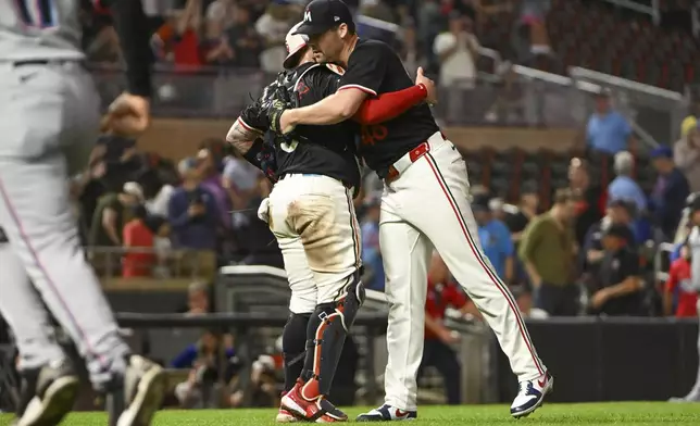 Minnesota Twins pitcher Justin Topa, right, celebrates with catcher Christian Vazquez after defeating the Miami Marlins 8-3 during a baseball game, Wednesday, Sept. 25, 2024, in Minneapolis. The Twins won 8-3. (AP Photo/Craig Lassig)